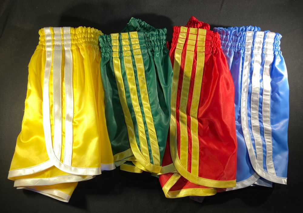Four pair homemade shorts.  A yellow and a baby blue with white leg trim and stripes, a red and a green with yellow leg trim and stripes 