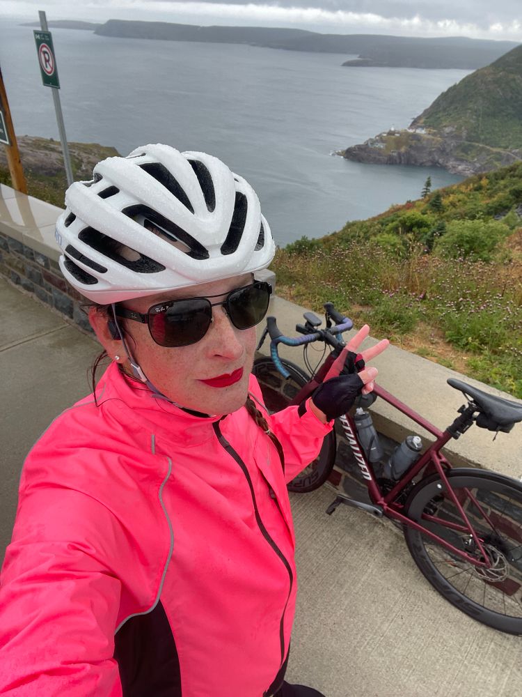 I’m standing next to my bike on top of Signal Hill. Fort Amherst, Cape Spear, and the Atlantic Ocean are behind me. It’s kinda rainy.