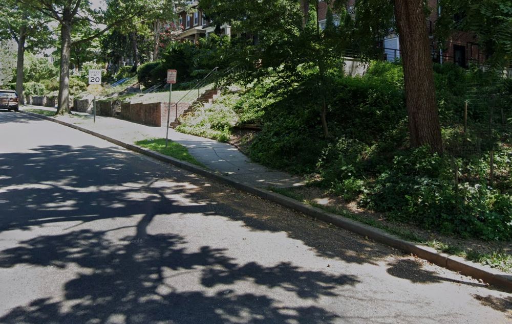 Photo showing a sidewalk stopping with a curb on one side and drop to a dirt path.