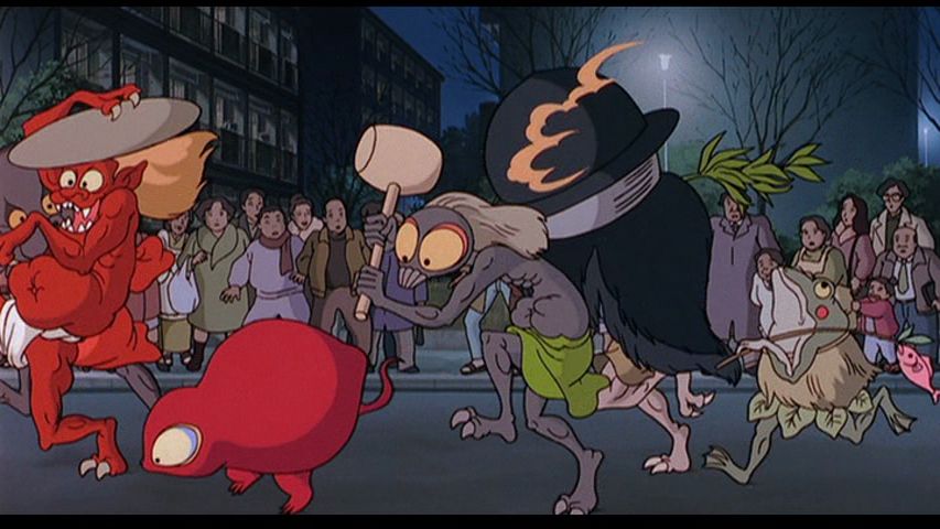 still from the yokai parade scene in pom poko. a bunch of little freaks are running down a street while normal people look on 