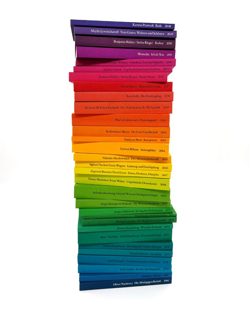 Ein Stapel mit Regenbogen-Büchern aus der Reihe edition suhrkamp.