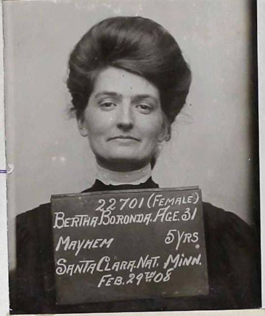 mug shot from 2/29/1908 of a white woman with hair up a lace high collar and a dark dress looking confidently at the camera. Her slate reads "22701 (Female) Bertha Boronda, Age 31 Mayhem 5 yrs. Santa Clara. Nat. Minn. Feb, 29th 08". She is definitely not sorry about the mayhem.