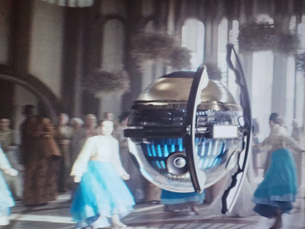 The spherical DJ droid from Andor S2 Episode 3 playing club remixes at a Chandrillan wedding reception