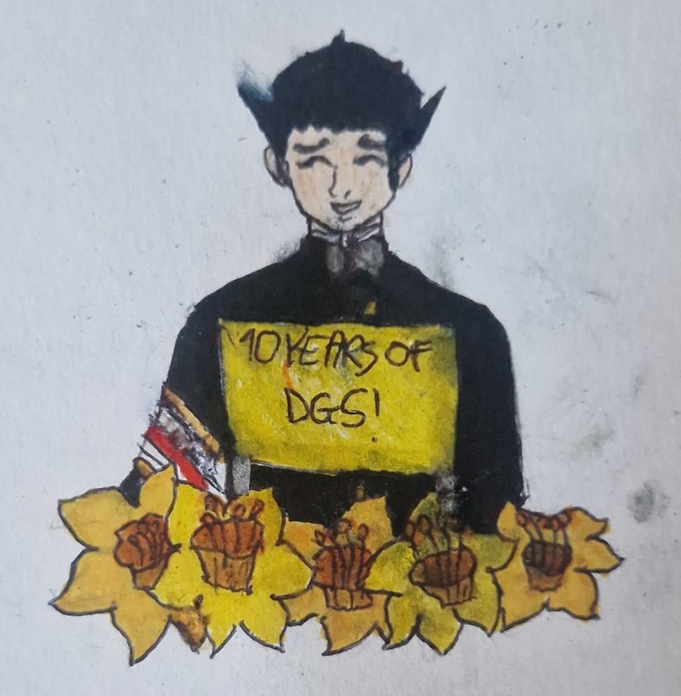 A bust of Ryunosuke Naruhodo, a tan-skinned man,  holding up a sign that says "10 YEARS OF DGS!" in black writing. He is wearing a black gakuran with gold buttons and silver brooches. Ryunosuke is wearing a gold, white and red defence attorney's badge. Below him are yellow and orange daffodils. 