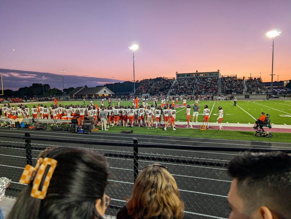 Watching a high school football game from the stands.