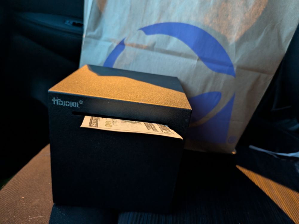 Box downlit by a streetlight before a bag of taco bell. 