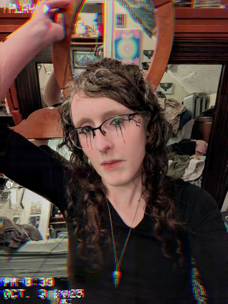 a tastefully glitchy selfie of a goth woman. there are a lot of mirrors.