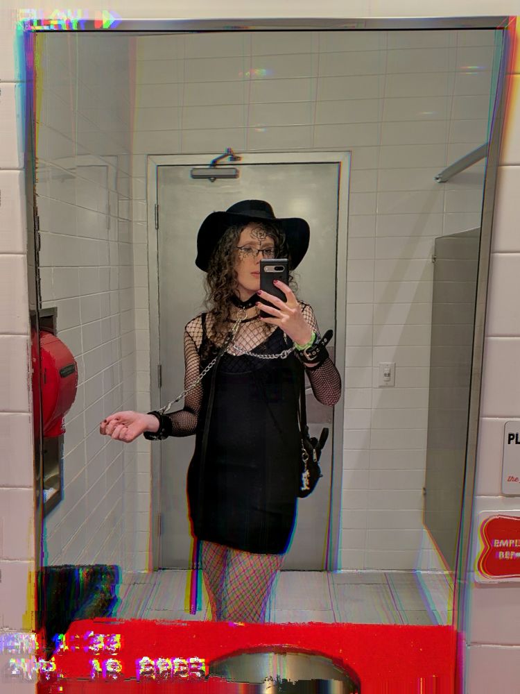 a slightly glitchy mirror selfie of a goth moth in chains