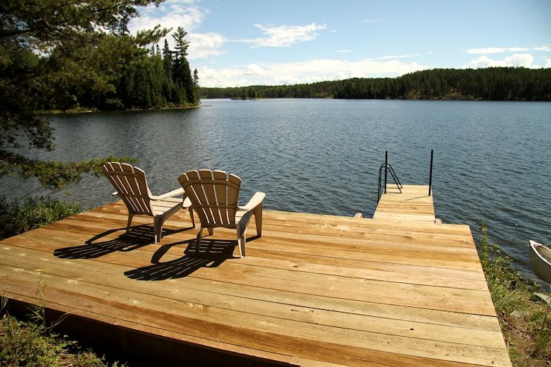 Muskoka chairs on a deck overlooking Falcon Lake at Whiteshell Provincial Park in Manitoba.