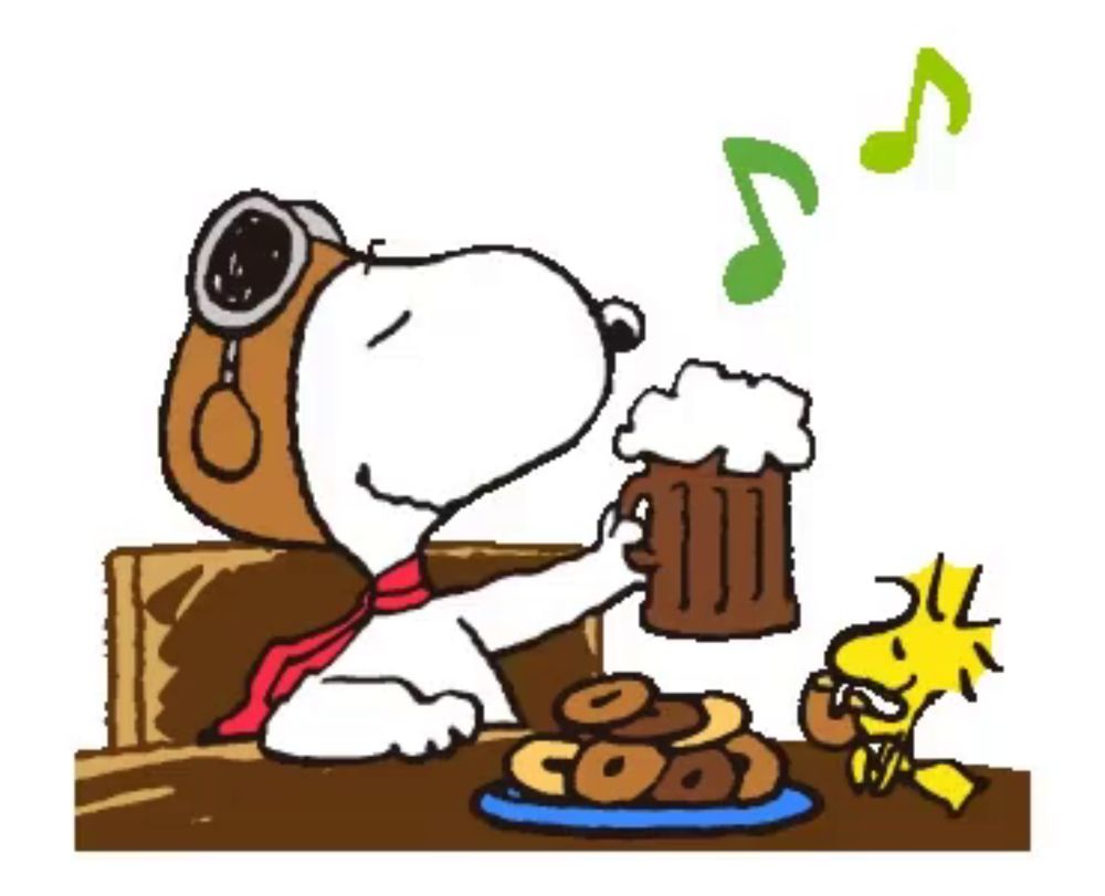 snoopy is sitting at a table with a mug of beer and woodstock is eating donuts .