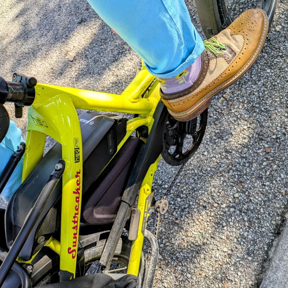 A photo of my right foot on the pedal of a 

yellow Tern HSD cargo bike with its name, Sunstreaker, in red on the seat stay

I'm wearing

tan leather and canvas spectator derby wingtips with lavender socks under a sky blue pantleg