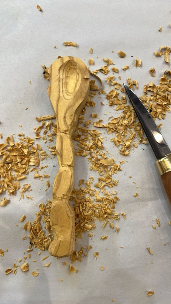 The front of a Mulberry spoon with a wiggly handle and circular grain pattern