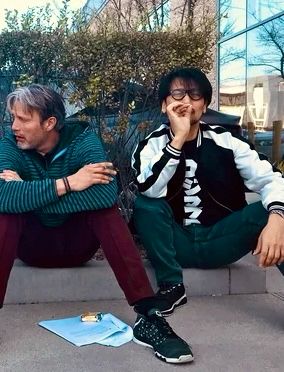 hideo kojima blastin a fake cig in a parking lot next to mads mikkelsen