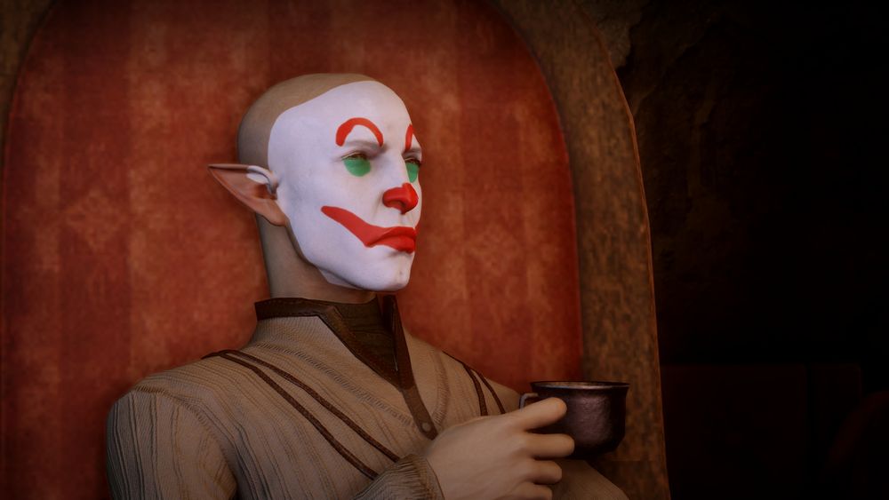 The image is of the character Solas from the game Dragon Age: Inquisition. The character has pale skin and is wearing clown-like makeup: a white base with red painted smile and green circles for eyes. He's dressed in a simple, light brown robe and holds a dark metal cup in his hand.