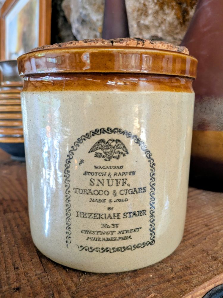 Old English ceramic snuff jar with design and these words: 

MACAUBAD

SCOTCH & RAPPER

SNUFF, TOBAOCO & CIGARS

MADE & SOLD

BY HEZEKIAH STARR

No 37

CHESTNUT STREET

PHILADELPHIA
