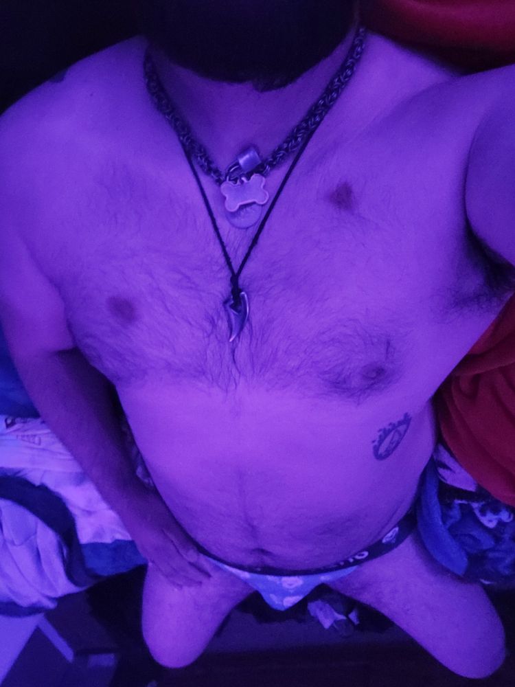 Masculine presenting person wearing only a jock showing off body. Laying down can see from knee up 