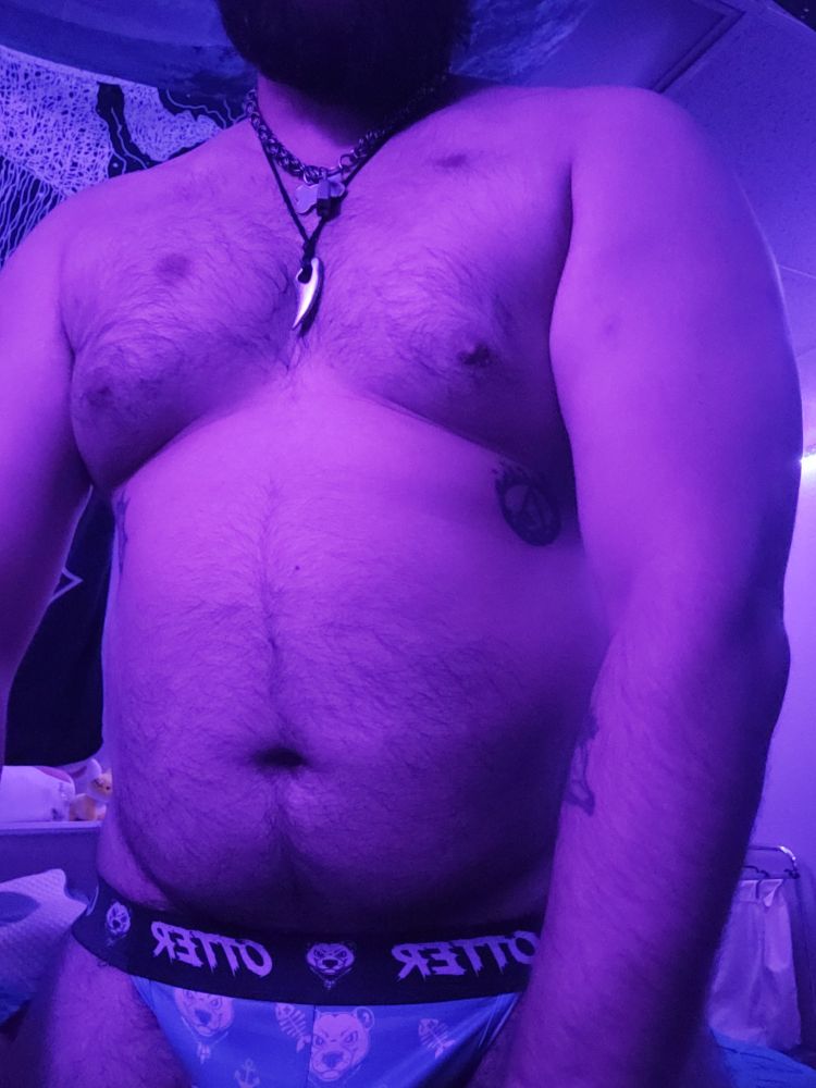 Masculine presenting person wearing only a jock showing off body. Thigh up facing forward 