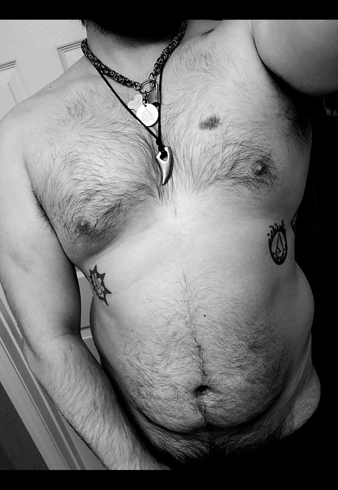 Masculine presenting person shirtless showing off torso. 