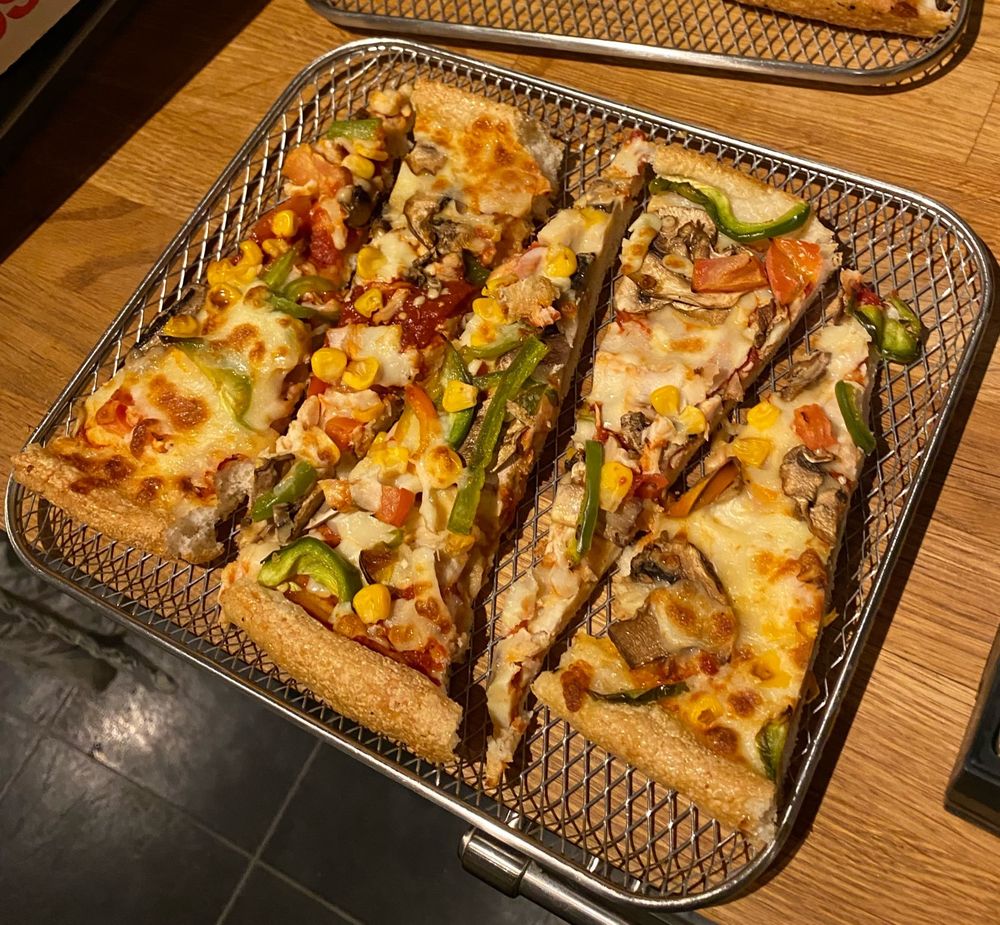 Pizza slices arranged with the crusts alternating so they fit in my air fryer