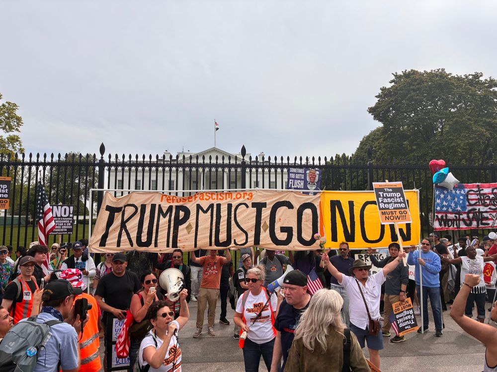 Manifestation devant la Maison Blanche à Washington avec une grande pancarte : « Trump must go Now »