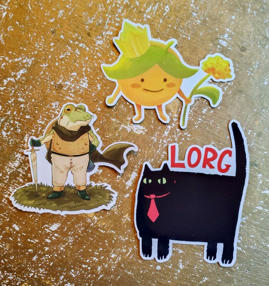 3 stickers are laid on top of a golf surface. The top sticker is a little Orange with arms and legs, smiling and holding a flower. He has a crown. The middle sticker is a frog in armor with a sword, standing like a dad who just mowed the lawn. The third and bottom is a large, angry square of a black cat with a red tie. Above him text reads "LORG."