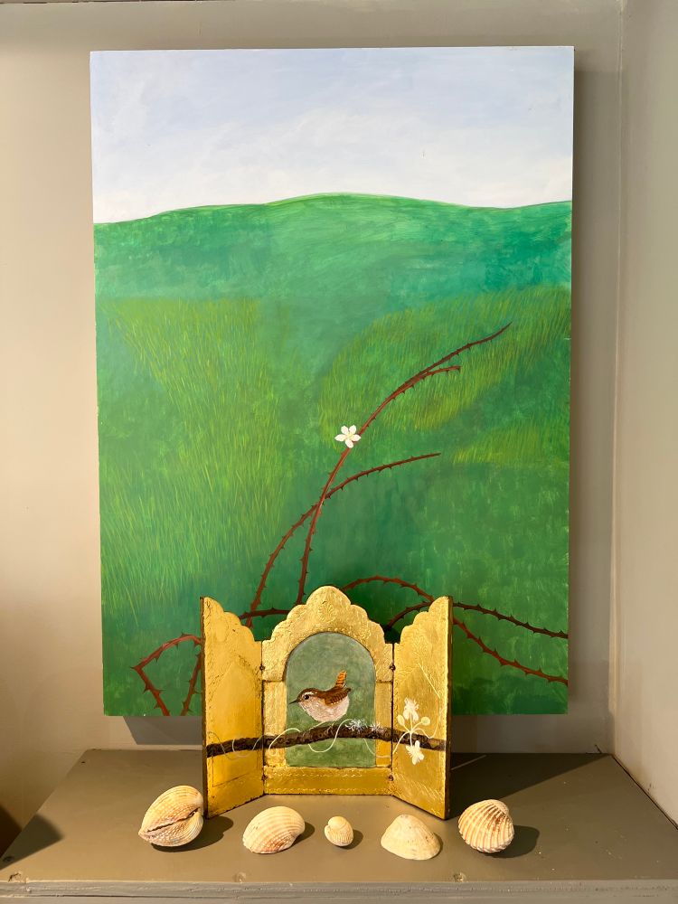 A wren icon in front of a green painting 
