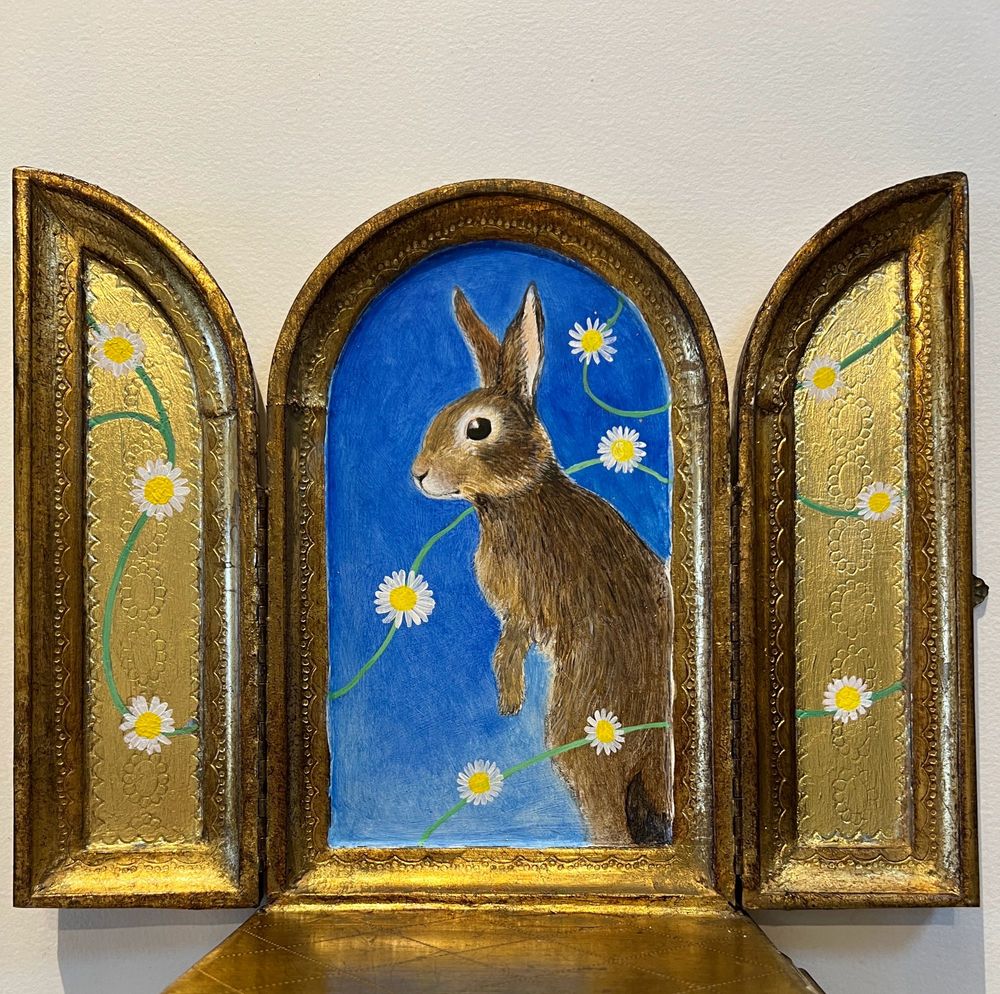 A rabbit icon painted on gold leaf laid on the vintage folding poplar panels of a musical box 
