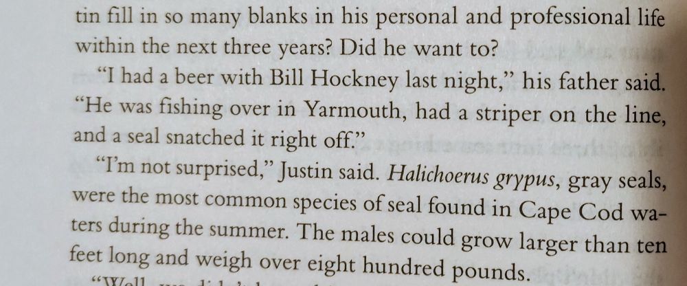 A book page reading "'I had a beer with Bill Hockney last night,' his father said. 'He was fishing over in Yarmouth, had a striper on the line, and a seal snatched it right off.' 
'I'm not surprised,' Justin said. Halichoerus grypus, gray seals, were the most common species of seal found in Cape Cod waters during the summer. The males could grow larger than 10 feet long and weigh over 800 pounds."