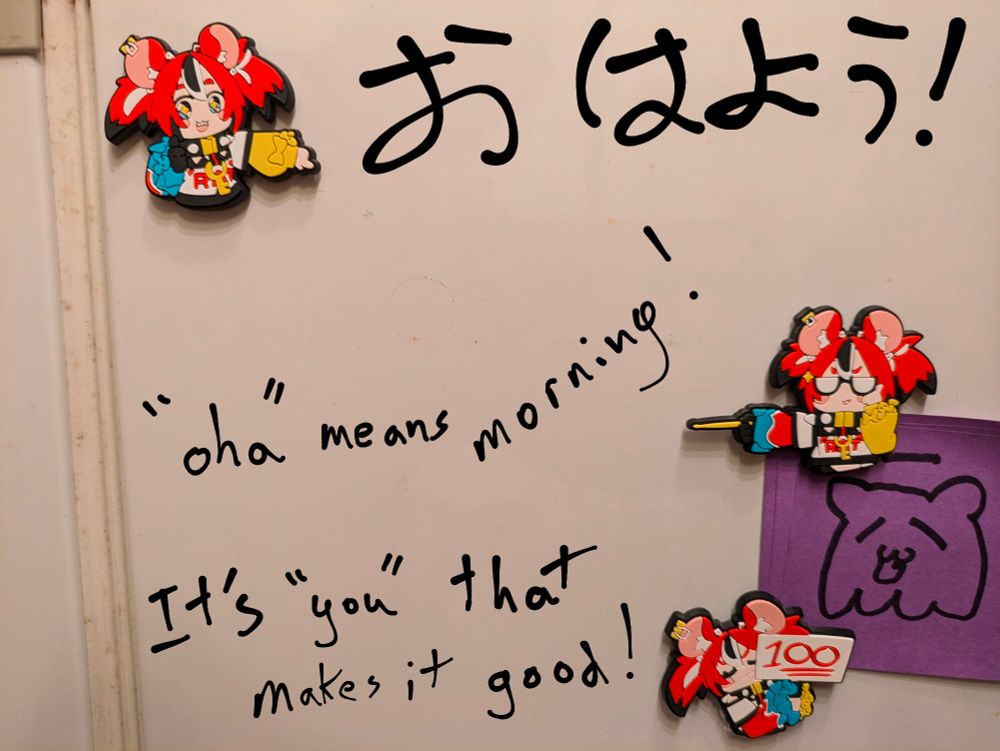 Refrigerator magnets on a refrigerator with the words "おはよう!" "'oha' means morning!" "It's 'you' that makes it good!" written by hand.  Translator note: ohayou means good morning, but not literally as the writing states.