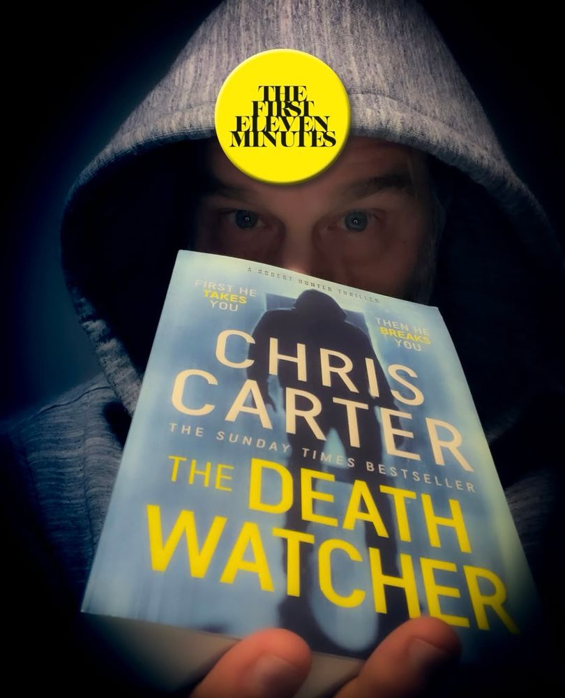 Shady character holding paperback version of ‘The Death Watcher’ by Chris Carter.