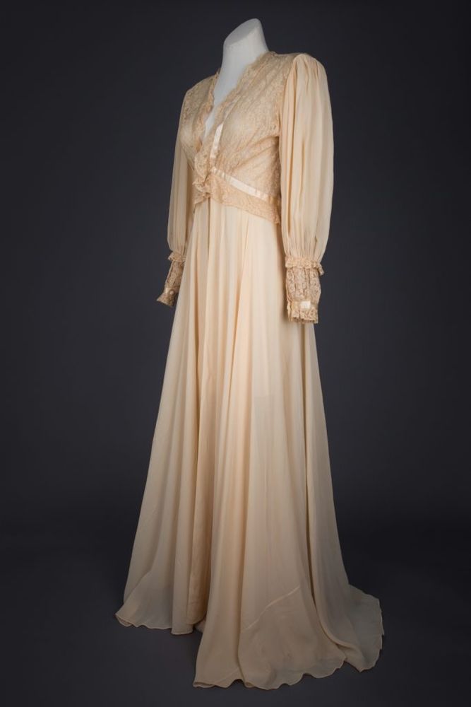 
A decadent peignoir in silk crêpe, with a voluminous skirt and full sleeves. The skirt is carefully has a carefully panelled diagonal cut to minimise fabric wastage whilst maintaining a full cut. The bodice of the garment is made of a machine lace, with the scallop edge forming a ruffled trim at the neckline, underbust and cuffs.

The garment has a number of luxurious techniques and details. Silk satin trims the neckline and cuffs and is applied by delicate hand stitches, and all the French seams are hand finished. The button fastening at the underbust has a hand stitched loop, and the buttons are covered with matching silk and lace.