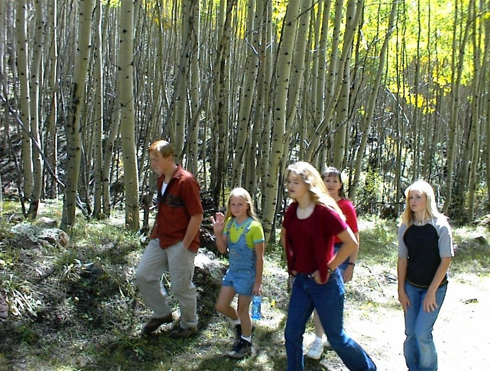 Mummer is the second from the right in a red shirt, walking with family