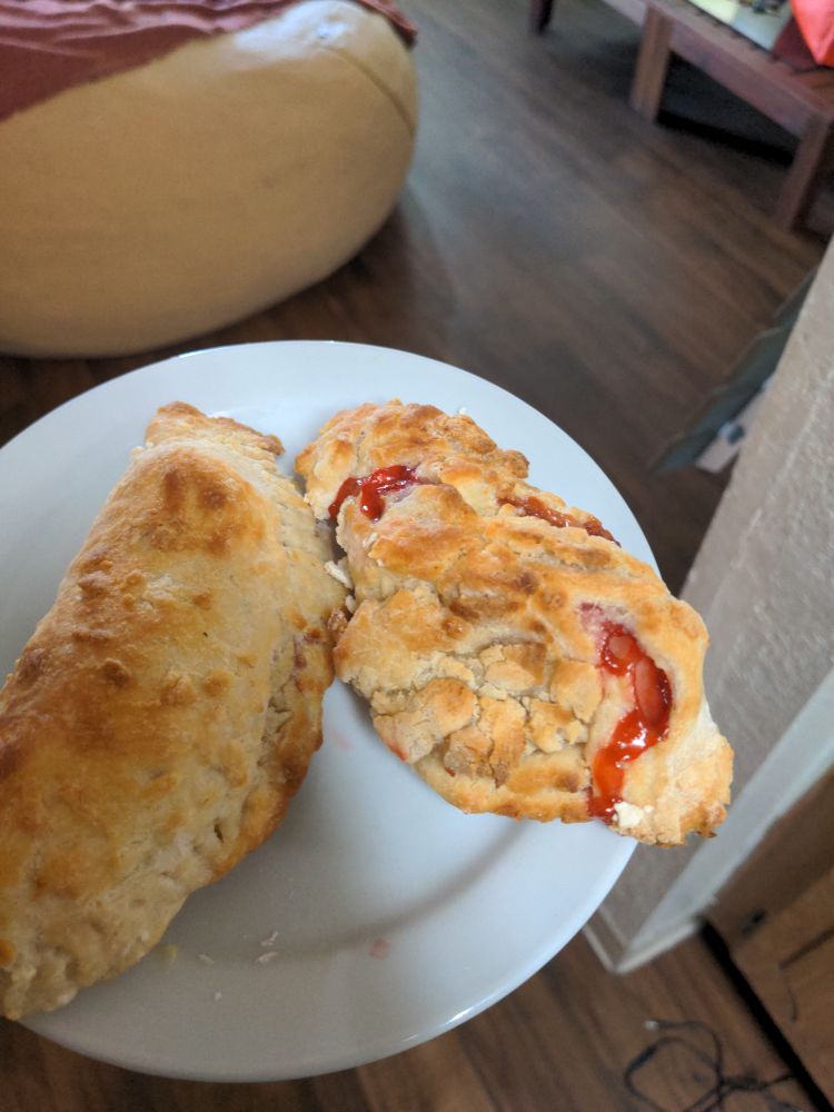 Two strawberry hand pies. One is a bit uglier than the other