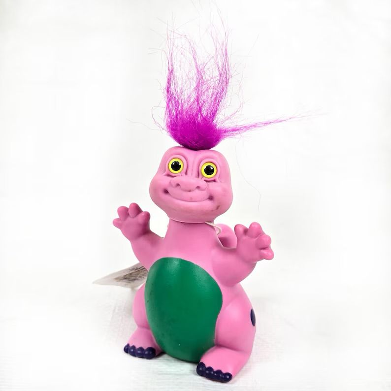 Little pink dinosaur body with a Troll doll head. It’s so cute. 