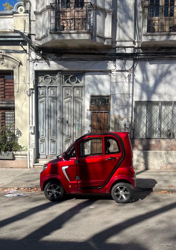 very small one person motorized vehicle in bright red (side view)