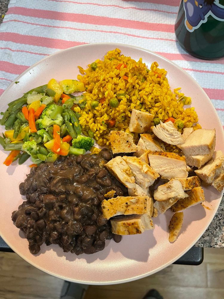 A plate of dinner:
Seasoned brown rice, cut baked chicken, black beans, and steamed vegetables.
