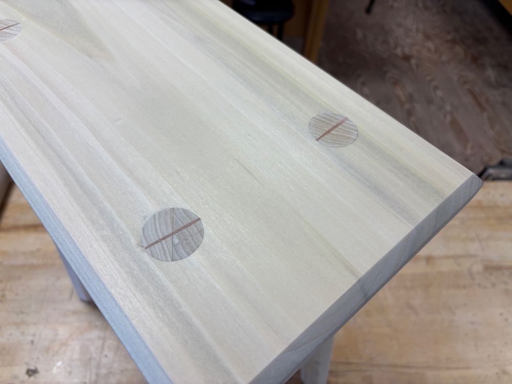 Detail view of wedged tenons in a staked stool. Cherry wedges in poplar. 