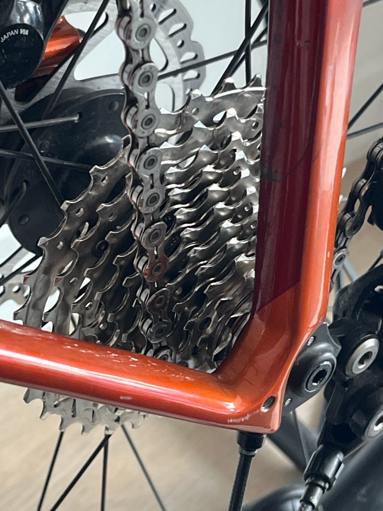 Photo of an orange bike with a closeup of the shiny, newly cleaned, drivetrain.
