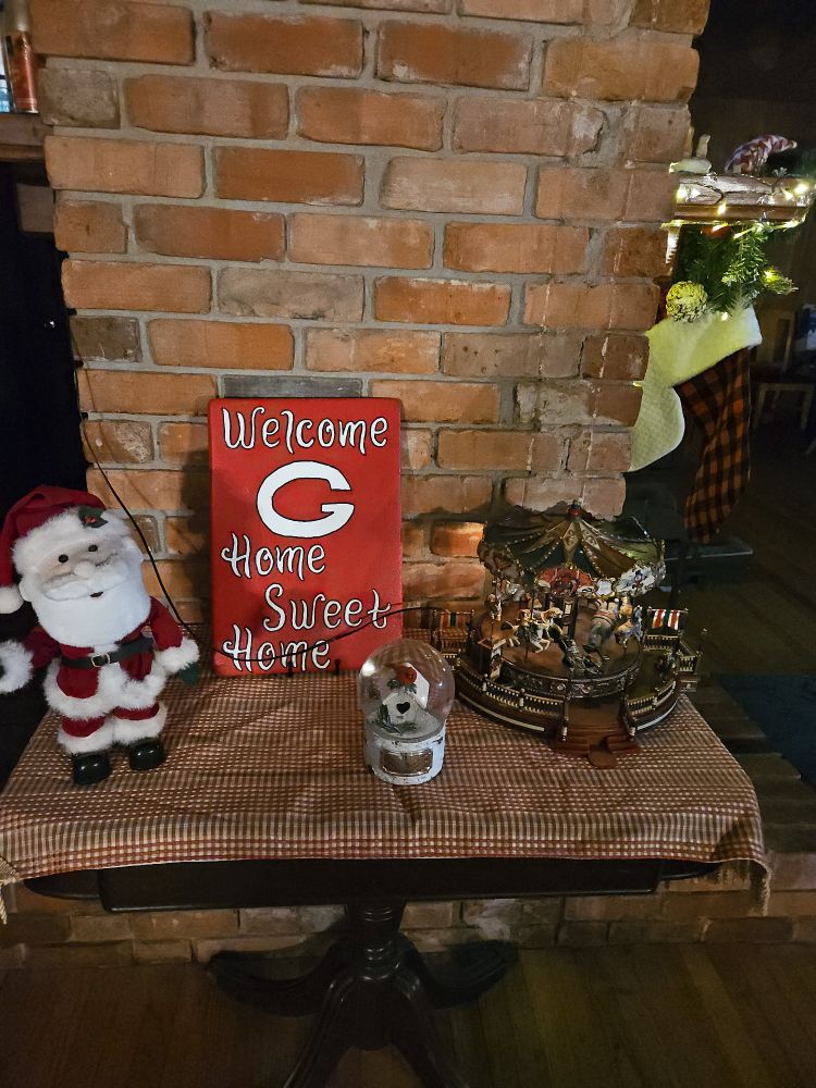 welcome to our home table with dancing santa, red bird snowglobe, and carousel 