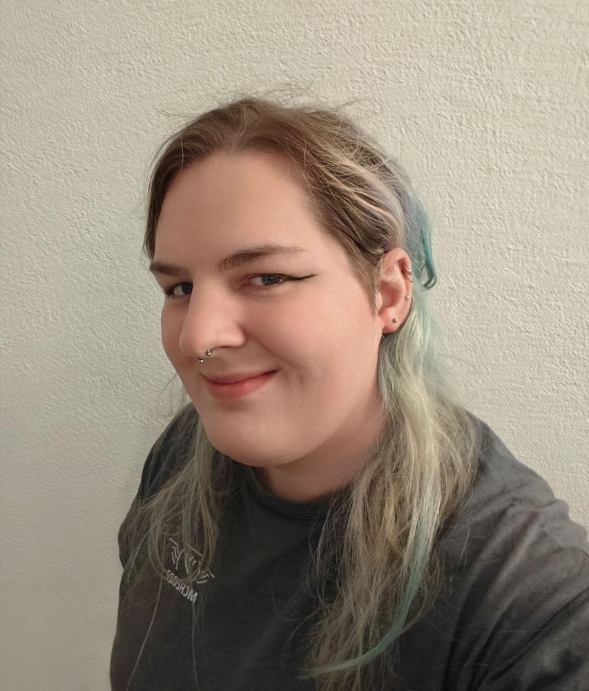 maya, a pale trans girl, is looking at the camera
