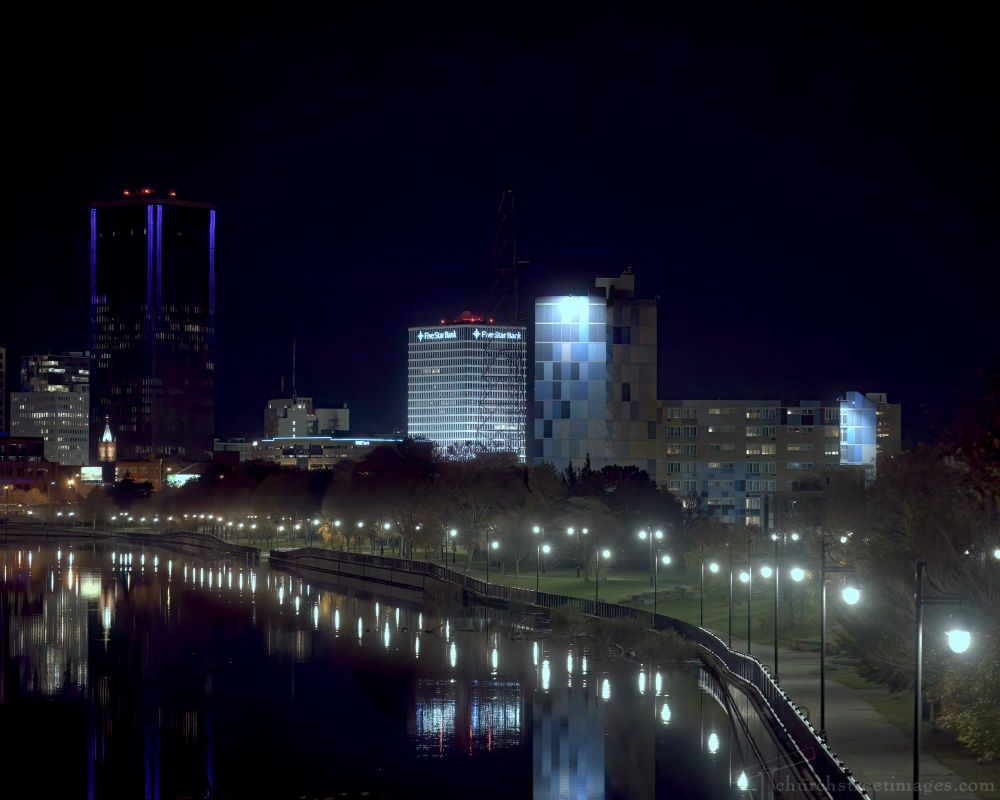 View of downtown Rochester, NY at night along the bank of the Genesee River