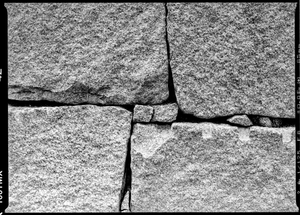 A detail shot of the previous wall showing a single intersection of 4 large stones that has smaller stones filling the gaps. 