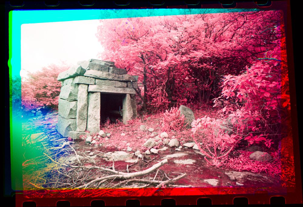 A small temple, with red vegetation in the background because of IR. 