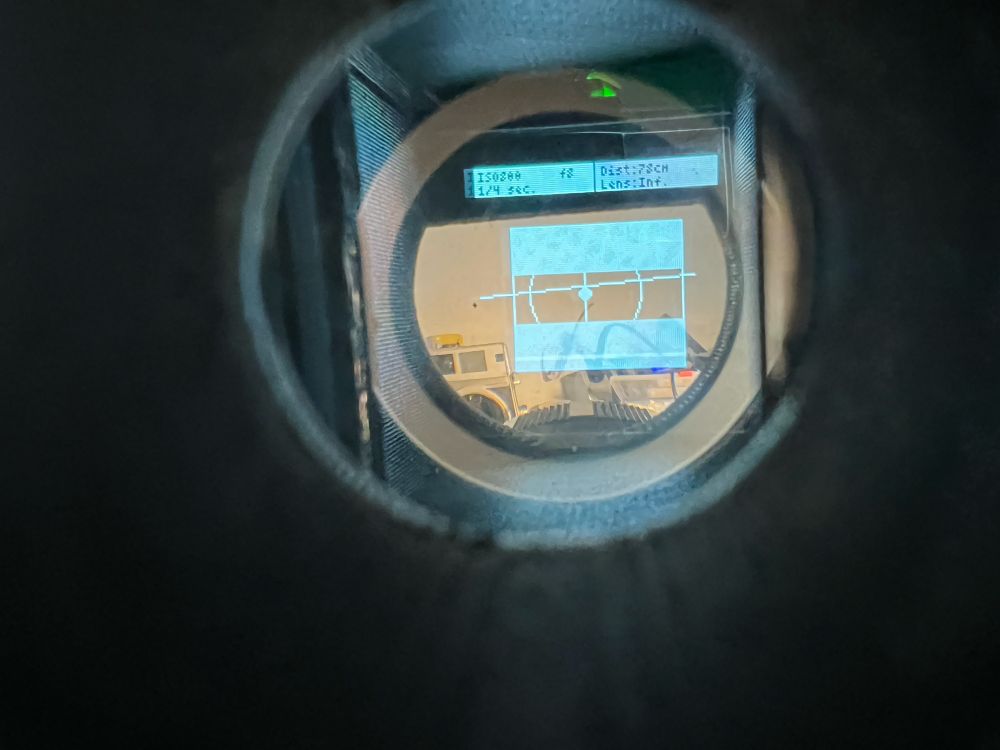 The in viewfinder display, visible is the light meter reading, the set iso, the measured rangefinder distance, and the set focus. In the center is the level indicator, the focus indicator and the mask (currently set to 35mm film and 90mm lens)