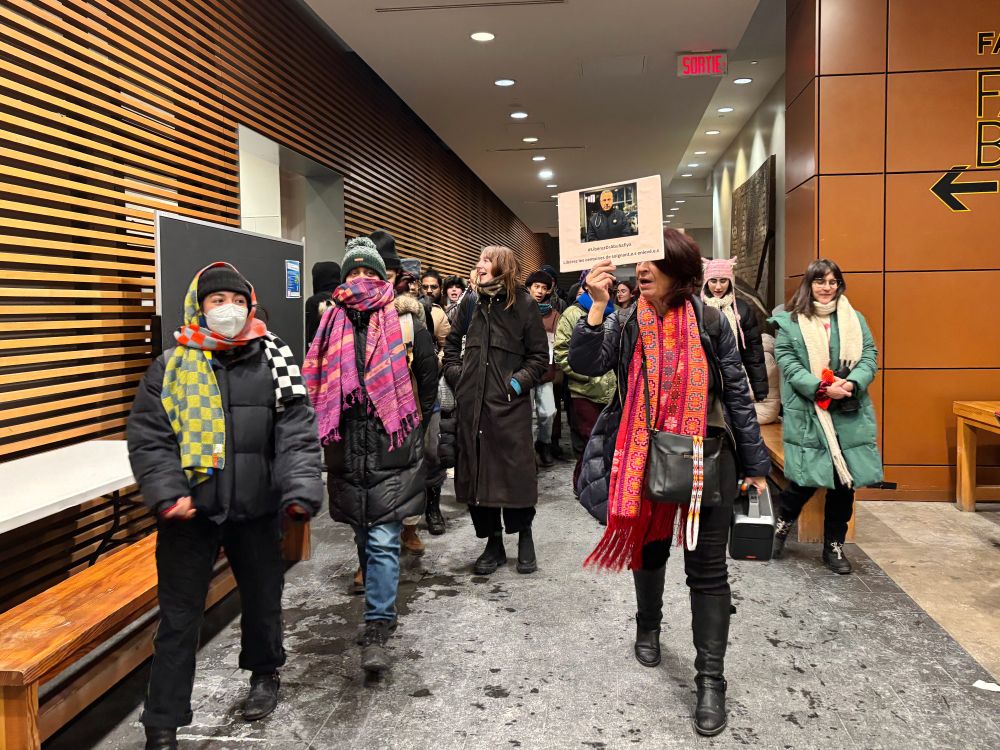Featuring artist Rehab Nazzal holding up a protest sign, leading a group of students, academics and artists through the halls of Concordia's EV building to the Bina Ellen Gallery, following her artist talk.
