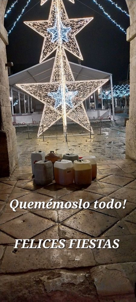 7 bidones con gasoil en el suelo con unas estrellas de Navidad iluminadas de fondo. Quemémoslo todo! FELICES FIESTAS