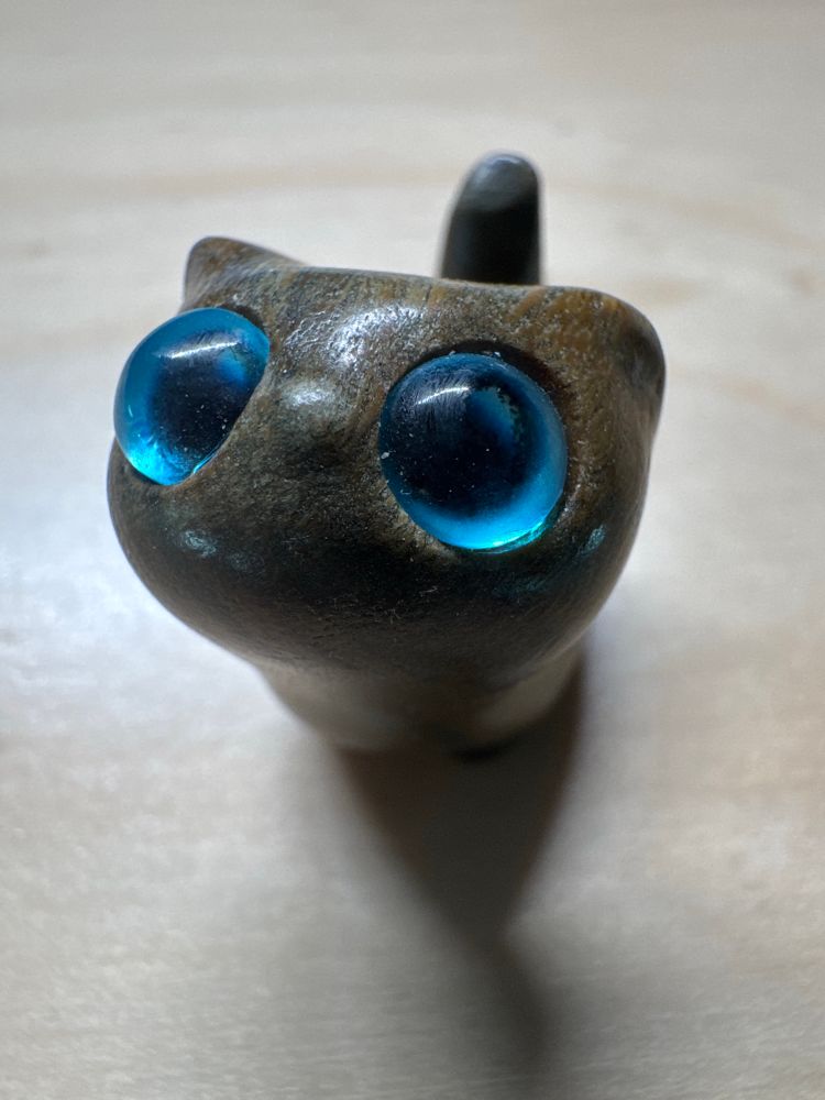 Un petit chat en bois avec de grands yeux bleus trop mignons 