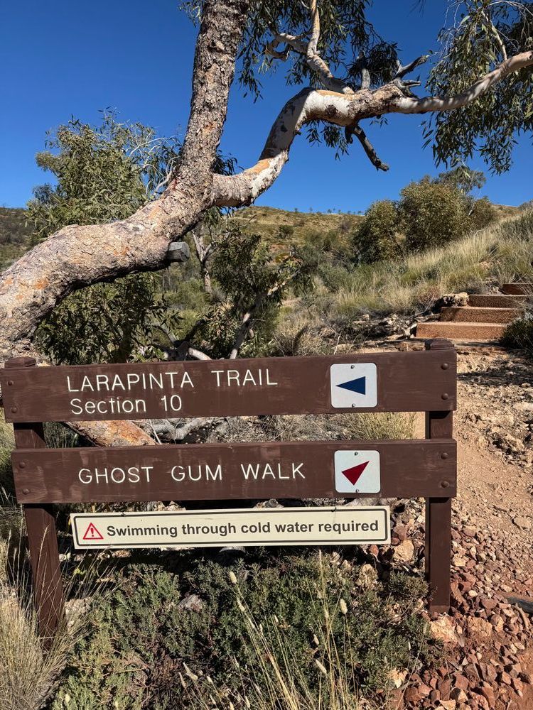 Deux panneaux de balade indiquant des chemins, l'un mentionne : "Caution, swimming through cold water required"