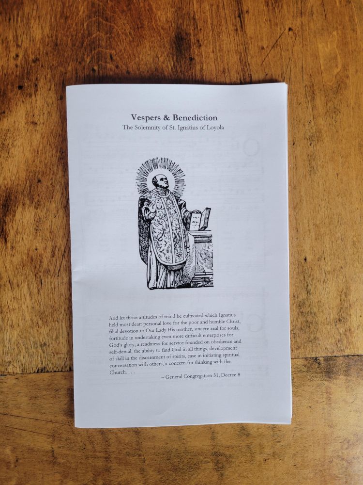 A booklet reading "Vespers and Benediction for the Solemnity of St. Ignatius of Loyola"