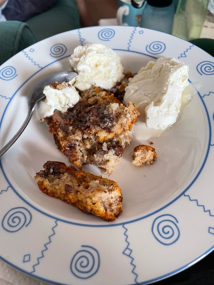 Bowl with a slice of banana bread with chocolate chunks and a couple of scoops of vanilla ice cream